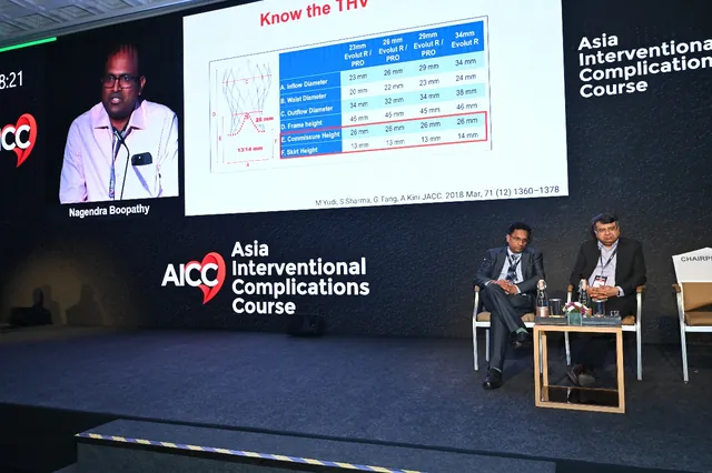A lecture underway, case slides on the screen behind the panel